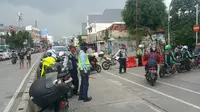 Penutupan Jalan Jatinegara, Jakarta Timur akibat air Kali Ciliwung yang belum surut, Selasa (6/2/2018) pagi. (Liputan6.com/Nanda Perdana Putra)