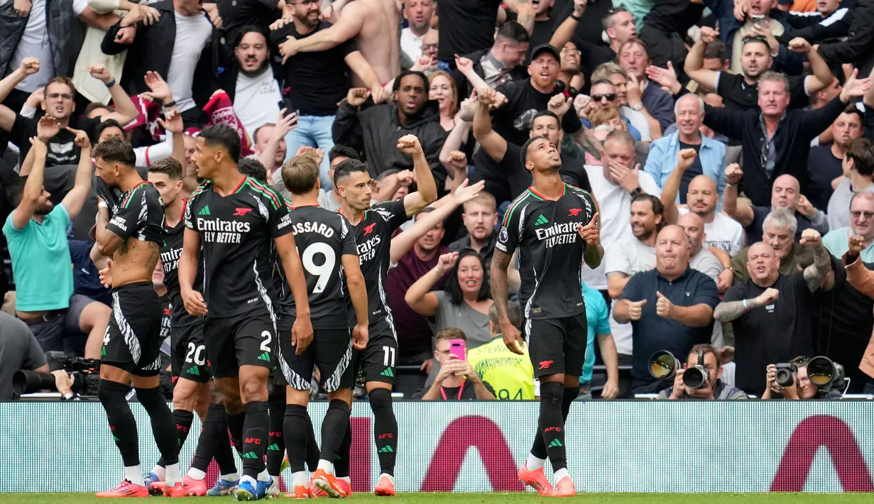 Pemain Arsenal, Gabriel Magalhaes (kanan) melakukan selebrasi dengan rekan setimnya setelah mencetak gol pembuka saat pertandingan Liga Premier Inggris melawan Tottenham Hotspur di London, Minggu 15 September 2024. (AP Photo/Kin Cheung)