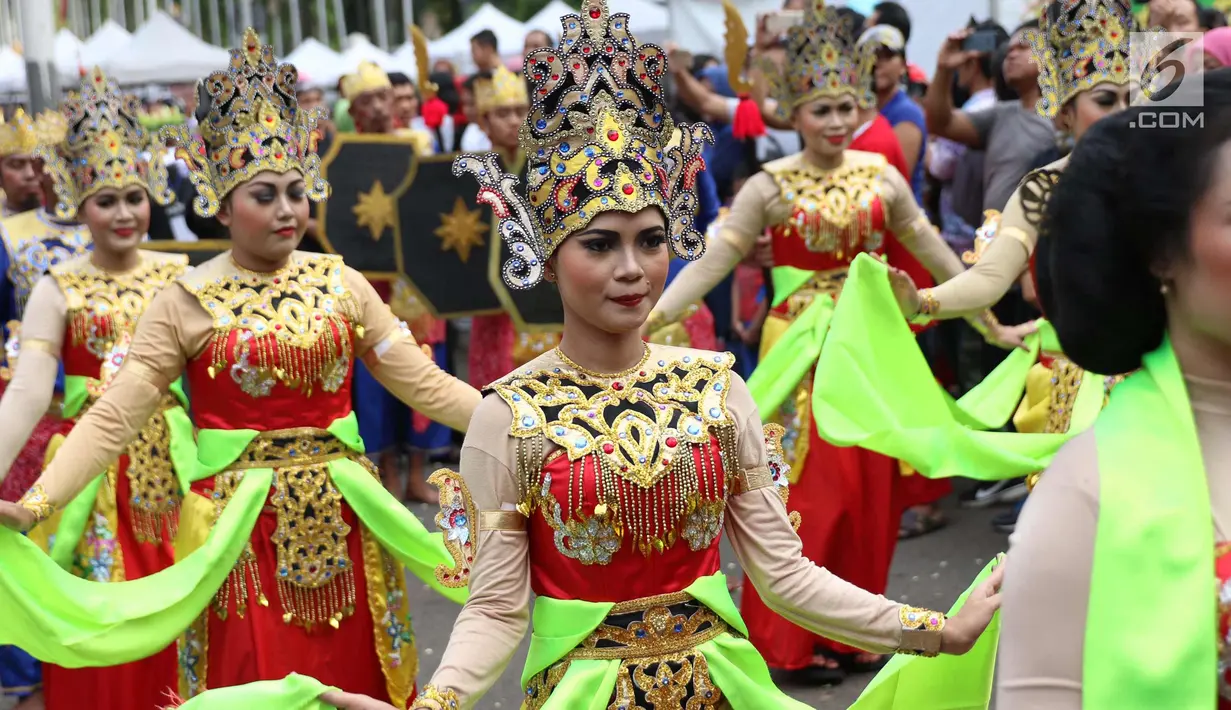 Sejumlah wanita menampilkan tarian daerah saat melakukan karnaval di jalan Pintu 1 Senayan, Jakarta, Minggu (24/9). Karnaval tersebut dilakukan dalam rangka HUT Gelora Bungkarno yang ke-55. (Liputan6.com/Angga Yuniar)