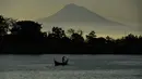 Seorang nelayan menarik jala saat memancing saat matahari terbit pada Hari Bumi di lepas pantai Banda Aceh (22/4/2021).  Hari Bumi dirancang untuk meningkatkan kesadaran dan apresiasi terhadap planet yang ditinggali manusia ini yaitu bumi. (AFP/Chaideer Mahyuddin)