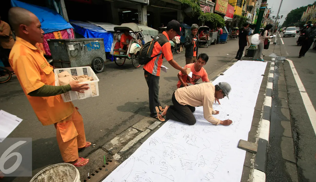 Juru parkir melakukan aksi menandatangani kain putih di jalan Malioboro,Yogyakarta, Jumat (11/3). Dalam aksinya mereka meminta dukungan kepada pengguna jalan yang melintas dan menuntut kejelasan relokasi yang bernurani. (Liputan6.com/Boy Harjanto)