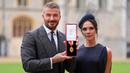 Mantan pesepak bola, Sir David Beckham (kiri) berfoto bersama dengan istrinya, Victoria Beckham sambil menunjukkan medali setelah dinobatkan gelar baru oleh raja Inggris, Charles III di Kastil Windsor, Berkshire, Inggris, Selasa (04/11/2025) waktu setempat. (AP Photo/Pool/Andrew Matthews)