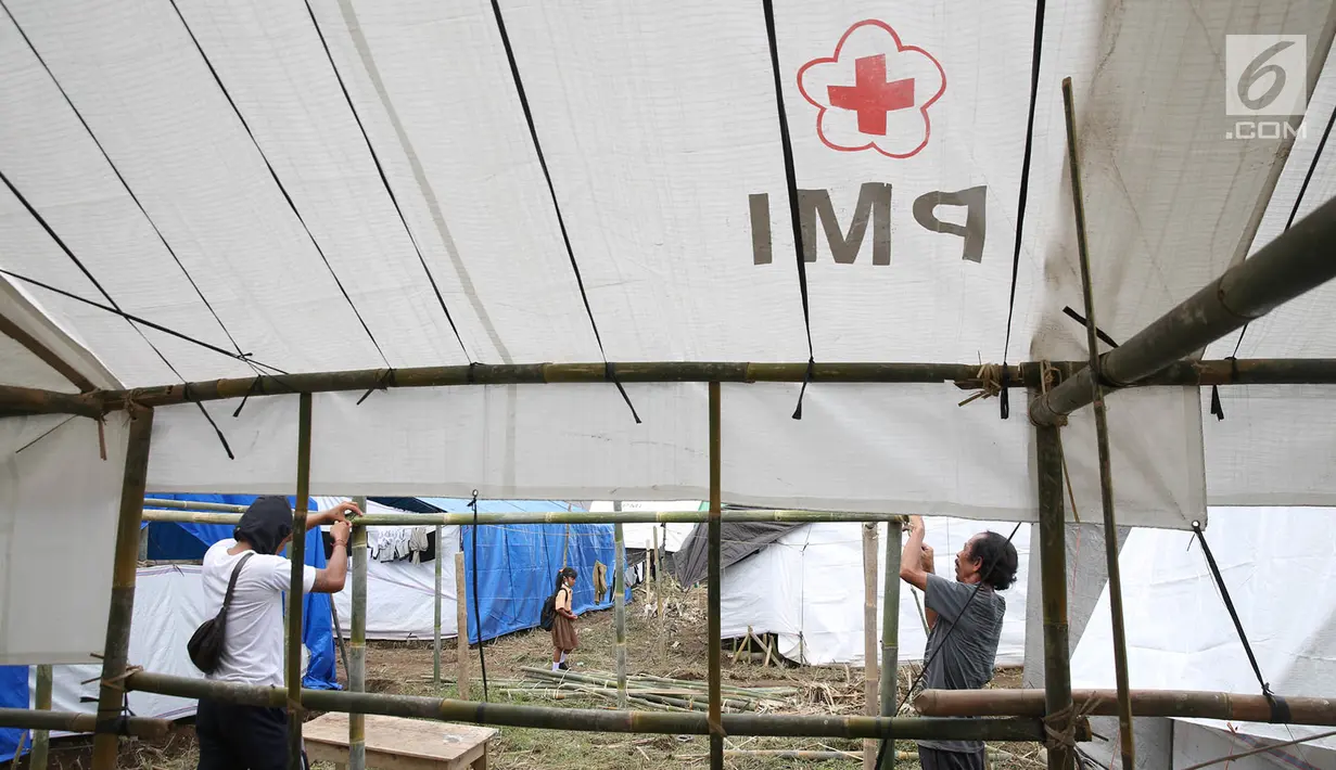 Warga pengungsi Gunung Agung mendirikan tenda di Posko Pengungsi Rendang, Bali, Sabtu (2/12). Bertambahnya jumlah pengungsi membuat mereka harus mendirikan tenda untuk tempat tinggal sementara. (Liputan6.com/Immanuel Antonius)