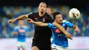 Penyerang AC Milan, Zlatan Ibrahimovic (kiri) berebut bola dengan pemain Napoli, Mario Rui  pada pertandingan lanjutan Liga Serie A Italia di Stadion San Paolo di Naples, Italia, Minggu, (12/7/2020). AC Milan bermain imbang 2-2 atas Napoli. (Spada/LaPresse via AP)