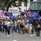 Demonstran berbaris di sepanjang Lambton Quay sebelum berkumpul di gedung Parlemen Selandia Baru, di Wellington, Selasa (9/11/2021). Ribuan warga Selandia Baru berdemonstrasi memprotes kebijakan vaksin covid-19 dan penguncian (lockdown) yang diterapkan negara itu. (Mark Mitchell/NZ Herald via AP)