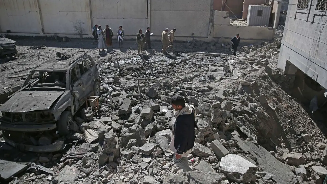 Sejumlah warga mengamati reruntuhan pusat penahanan Houthi yang diserang pasukan koalisi Saudi dari udara di Sanaa (13/12/2017).