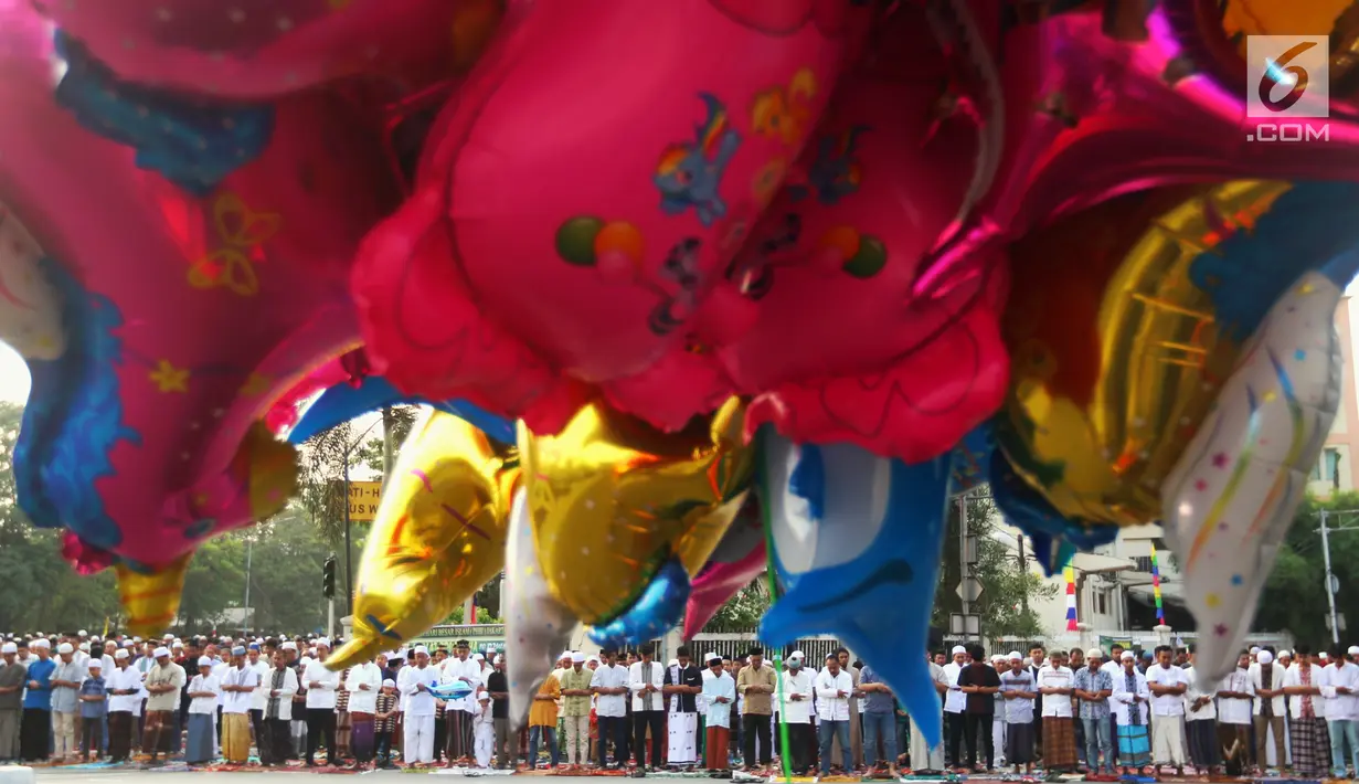 Sejumlah balon berjajar saat umat muslim melaksanakan salat Idul Adha 1439 H di Monumen Perjuangan Jatinegara, Jakarta Timur, Rabu (22/8). (Liputan6.com/JohanTallo)