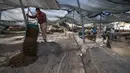 Para arkeolog dan pekerja menggali situs penggalian di mana telur ayam berusia 1.000 tahun ditemukan di Kota Yavne, Israel, Rabu (9/6/2021). Telur ayam tersebut ditemukan di tengah-tengah kotoran manusia. (Emmanuel DUNAND/AFP)