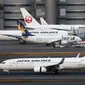 Pesawat Japan Airlines terlihat pada landasan di Bandara Internasional Haneda, Tokyo, Jepang, Senin (29/11/2021). Jepang melarang masuk semua warga asing terkait penyebaran varian baru virus corona COVID-19, Omicron. (AP Photo/Koji Sasahara)