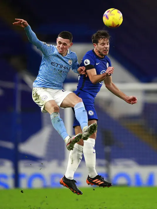 Pemain Manchester City Phil Foden (kiri) berebut bola udara dengan pemain Chelsea Cesar Azpilicueta pada pertandingan Liga Inggris di Stamford Bridge, London, Inggris, Minggu (3/1/2021). Manchester City mempermalukan Chelsea dengan skor 3-1. (AP Photo/Ian Walton/Pool)