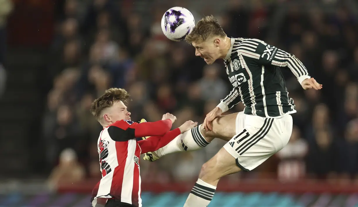 Striker Manchester United, Rasmus Hojlund (kanan) menyundul bola di bawah tekanan striker Brentford, Keane Lewis-Potter pada laga pekan ke-30 Premier League 2023/2024 di Gtech Community Stadium, London, Sabtu (30/3/2024). (AP Photo/Ian Walton)