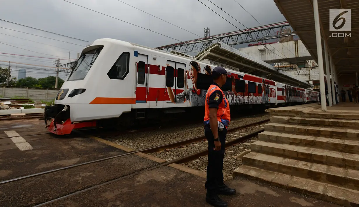 Petugas berdiri saat rangkaian kereta Commuter Line melintas di Stasiun Manggarai, Jakarta, Selasa (22/1). PT. Kereta Commuter Indonesia (KCI) menutup jalur 10 di Stasiun Manggarai guna mempercepat proses revitalisasi. (Merdeka.com/Imam Buhori)