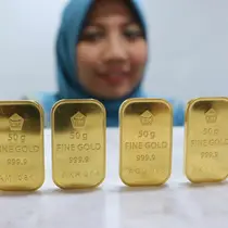 Seorang pegawai menunjukan emas batangan di Jakarta, Senin (10/10). Harga jual emas PT Aneka Tambang (Persero) Tbk (Antam) pada perdagangan awal pekan ini terpantau stagnan. (Liputan6.com/Angga Yuniar)