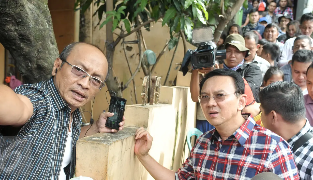 Warga memberi tahu Ahok arah menuju pinggir sungai Ciliwung saat blusukan di wilayah Cililitan, Jakarta, Rabu (28/12). Dalam blusukannya tersebut Ahok mencari tahu permasalahan banjir di Cililitan Kecil. (Liputan6.com/Yoppy Renato)