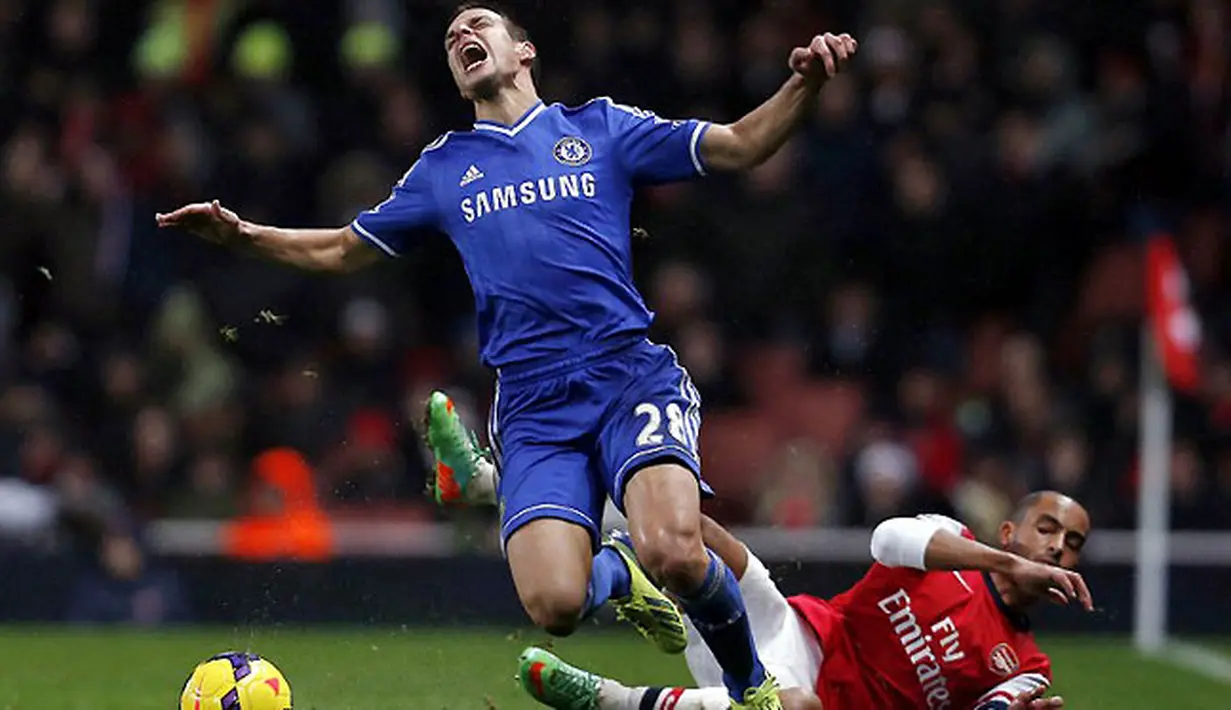 Bek Chelsea Cesar Azpilicueta mendapatkan tekel keras dari striker Arsenal Theo Walcott pada pertandingan sepak bola Liga Inggris antara Arsenal vs Chelsea di Stadion Emirates, London (24/12/13). (AFP/Adrian Dennis)