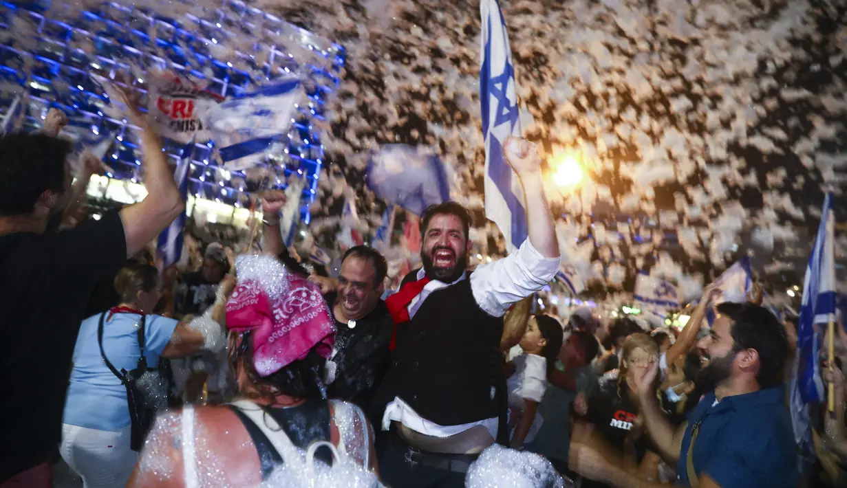 Warga Israel merayakan pelantikan pemerintahan baru di Tel Aviv, Israel, Minggu (13/6/2021). Parlemen Israel telah memberikan suara mendukung pemerintahan koalisi baru yang secara resmi mengakhiri 12 tahun pemerintahan bersejarah Perdana Menteri Benjamin Netanyahu. (AP Photo/Oded Balilty)