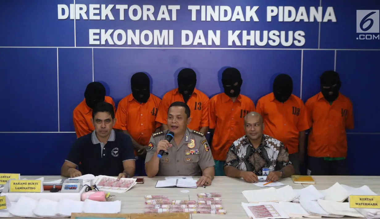 Analis Kebijakan Humas Polri Kombes Pol Sulistyo Pudjo (tengah) bersama Kadiv Penanggulangan Uang Palsu Bank Indonesia, Asral Mashuri (kanan) menunjukkan barang bukti uang palsu saat rilis di Jakarta, Jumat (16/3). (Liputan6.com/Arya Manggala)