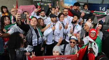 Para atlet Olimpiade Palestina dan anggota delegasi berpose dengan para pendukungnya setibanya di Bandara Charles-de-Gaulle, Roissy-en-France, sebelah utara Paris, pada 25 Juli 2024. (Ahmad GHARABLI/AFP)