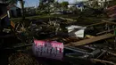 Sebuah tanda yang mengiklankan persewaan liburan terpasang pada sepotong kayu di tengah puing-puing yang berserakan dari rumah-rumah yang hancur dan usaha di Horseshoe Beach, Florida, satu hari setelah lewatnya Badai Idalia, Kamis (31/8/2023). (AP Photo/Rebecca Blackwell)