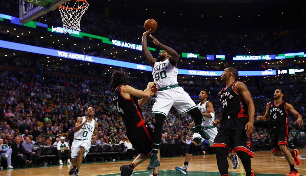 Pemain Cetics, Amir Johnson #90 melakukan tembakan saat dihadang pemain Toronto Raptors, Luis Scola #4 pada lanjutan NBA di TD Garden, Boston, Massachusetts, Kamis (24/3/2016) WIB. Celtics menang 91-79. (Maddie Meyer/Getty Images/AFP)