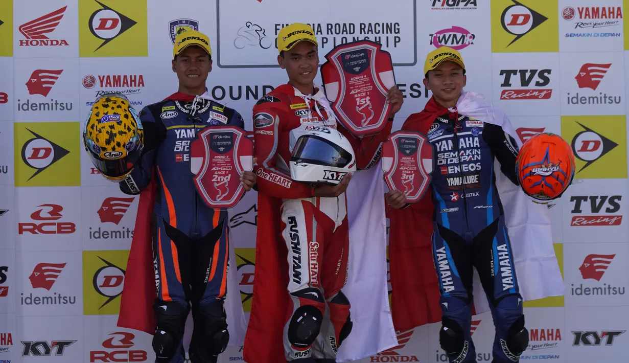 Juara Race 1 kelas Asia Production 250 (AP250), Herjun Atna Firdaus (tengah) diapit dua pembalap Yamaha Racing Indonesia, peringkat kedua Aldi Satya Mahendra (kiri) dan peringkat ketiga Wahyu Nugroho usai penyerahan trofi di atas podium pada ajang Asia Road Racing Championship (ARRC) 2023 di Sirkuit Mandalika, Lombok, Sabtu (12/8/2023). (Dok. AHRT)