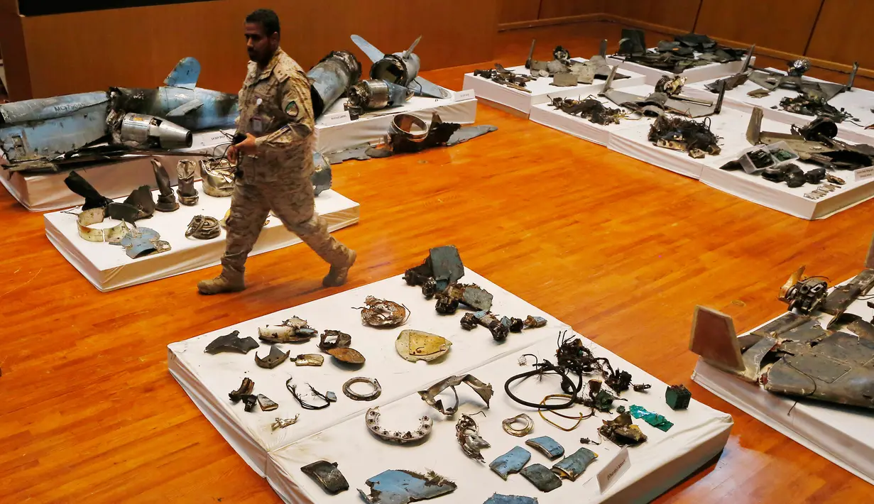 Perwira militer melewati puing-puing rudal dan drone yang digunakan dalam serangan kilang minyak Aramco pada konferensi pers di Riyadh, Arab Saudi, Rabu (18/9/2019). Kendati pemberontak Houthi Yaman mengklaim serangan itu, Amerika Serikat menuduh Iran berada di belakangnya. (AP Photo/Amr Nabil)
