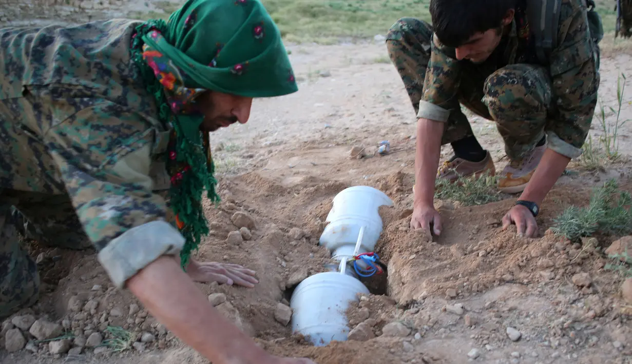 Anggota YBS yang berafiliasi dengan Partai Pekerja Kurdistan (PKK) memasang ranjau  di sebuah jalur yang biasa dilintasi ISIS, Irak utara, 30 April 2016. Di Irak dan Suriah banyak muncul kelompok-kelompok yang memerangi ISIS. (REUTERS/Goran Tomasevic)