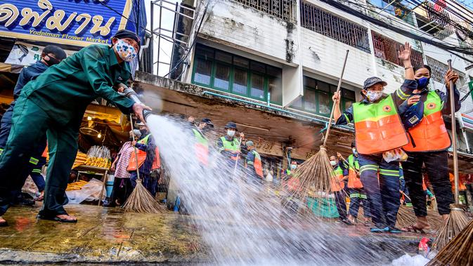 Pekerja Otoritas Metropolitan Bangkok menyapu membersihkan dan mendisinfeksi Pasar Bunga Yodpiman di Bangkok (6/1/2021). Total kematian meningkat menjadi 65 orang di Thailand. (AFP/Mladen Antonov)