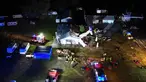 Gambar udara memperlihatkan kendaraan darurat berada dekat lokasi jatuhnya pesawat kecil Cessna 208 yang menabrak hanggar lapangan terbang di Desa Chrcynno, dekat Warsawa, Polandia, Senin (17/7/2023). Insiden tersebut lantas menewaskan lima orang. (Damien SIMONART/AFP)