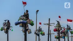 Peserta mengikuti perlombaan panjat pinang di pantai Ancol, Jakarta, Sabtu (17/8/2024). (Liputan6.com/Angga Yuniar)