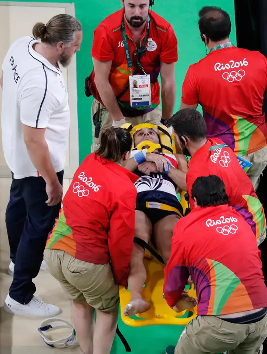 Atlet senam artistik Prancis Samir Ait Said ditandu keluar oleh tim medis setelah mengalami cedera pada babak kualifikasi Olimpiade Rio 2016 di Rio Olympic Arena, Brasil, Minggu (7/8). Samir gagal mendarat dan membuat kakinya patah. (Thomas COEX/AFP)