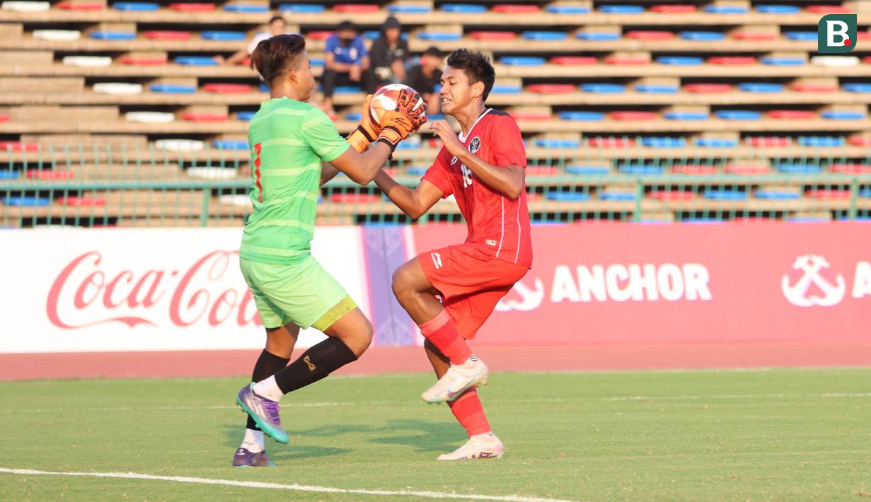 <p>Striker Timnas Indonesia U-22, Titan Agung Fawwazi (kanan) berusaha mencetak gol ke gawang Myanmar yang dikawal kiper Pyae Phyo Thu pada laga kedua Grup A SEA Games 2023 di Olympic Stadium, Phnom Penh, Kamboja, Kamis (4/5/2023). (Bola.com/Abdul Aziz)</p>