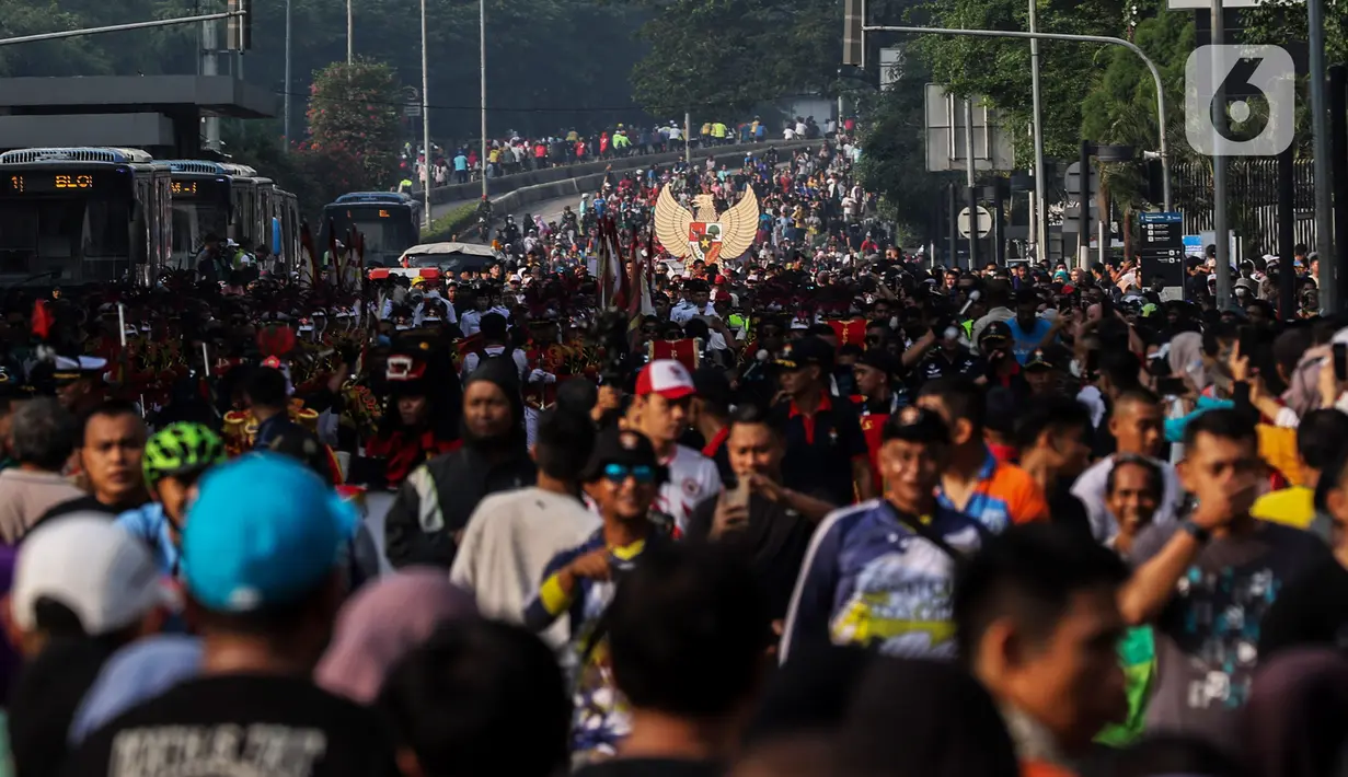 Warga menyaksikan Kirab Pancasila saat Hari Bebas Kendaraan Bermotor (HBKB) di kawasan Bundaran HI, Jakarta, Minggu (28/5/2023).  (Liputan6.com/Johan Tallo)