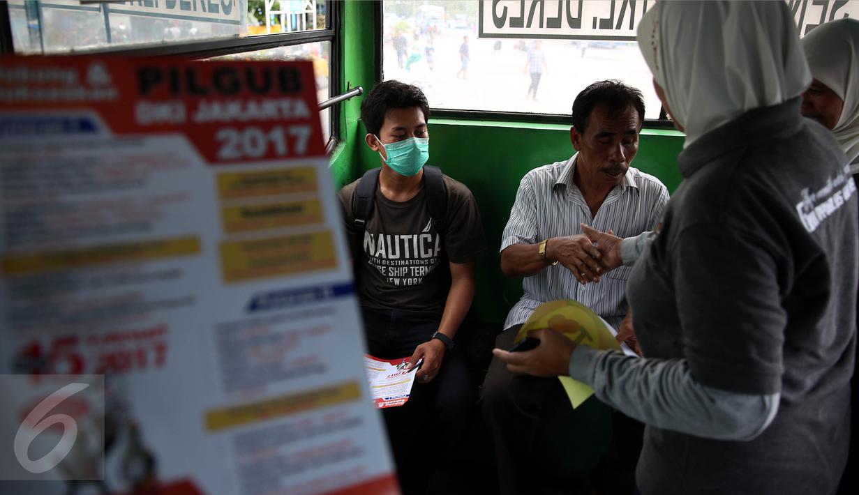 Petugas KPU membagikan brosur kepada penumpang bus saat sosialisasi Pilkada DKI 2017 di Terminal Senen, Jakarta, Minggu (18/12). Sosialisasi pesta demokrasi ini guna mencegah banyaknya pemilih yang golongan putih atau golput. (Liputan6.com/Johan Tallo)