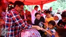 Calon Wakil Gubernur DKI Jakarta Djarot Saiful Hidayat saat membagikan buku kepada warga Petukangan Utara, Jakarta, Selasa (29/11). Djarot akan mempertahankan program KJP untuk menjamin pendidikan di Jakarta. (Liputan6.com/Gempur M Surya)