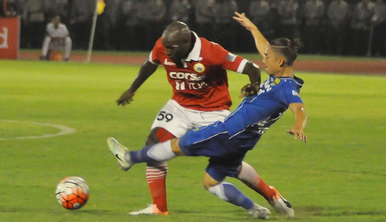 Striker Persija Jakarta, Pacho Kenmogne, dihadang gelandang Persib Bandung, Kim Kurniawan, pada laga Torabika Soccer Championship 2016 di Stadion Manahan, Jawa Tengah, Sabtu (5/11/2016). Kedua tim bermain imbang 0-0. (Bola.com/Romi Syahputra)