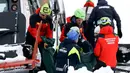 Petugas mengevakuasi korban helikopter yang jatuh di kawasan ski Campo Felice, Italia, Selasa (24/1). Berdasarkan laporan awal helikopter tersebut jatuh usai menjemput seseorang yang terluka akibat kecelakaan ski. (AP Photo)