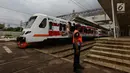 Petugas berdiri saat rangkaian kereta Commuter Line melintas di Stasiun Manggarai, Jakarta, Selasa (22/1). PT. Kereta Commuter Indonesia (KCI) menutup jalur 10 di Stasiun Manggarai guna mempercepat proses revitalisasi. (Merdeka.com/Imam Buhori)