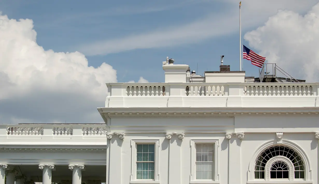 Bendera Amerika Serikat berkibar setengah tiang di Gedung Putih, Washington DC, Minggu (4/8/2019). Presiden Donald Trump memerintahkan pengibaran bendera setengah tiang di semua gedung pemerintah untuk mengenang korban tewas dalam dua penembakan massal di El Paso, Texas, dan Ohio. (AP/Andrew Harnik)