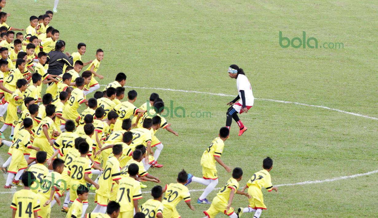 Ratusan Anak-anak SSB kota Padang berlari menyerang ke gawang Legenda Timnas Indonesia saat dihadang Rocky Putiray  pada ajang Irman gusman Cup 2016 diStadion Agus Salim, Padang, Minggu (13/3/2016). (Bola.com/Nicklas Hanoatubun)