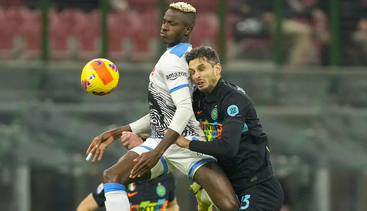 Penyerang Napoli Victor Osimhen (kiri) dan bek Inter Milan Andrea Ranocchia melompat saat berebut bola dalam lanjutan Liga Italia di Giuseppe Meazza, Senin (22/11/2021) dini hari WIB. Inter Milan sukses mengandaskan Napoli dengan skor tipis 3-2. (AP Photo/Antonio Calanni)