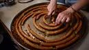 Seorang wanita menyiapkan potongan churros di toko churreria kuno yang didirikan pada tahun 1872 di Pamplona, Spanyol, Senin (10/7/2023). Churros merupakan sarapan khas selama berlangsungnya Festival San Fermin. (AP Photo/Alvaro Barrientos)