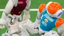 Robot tim Italia, nomadZ (kanan) dan robot tim Luxembourg berebut bola pada ajang 'RoboCup German Open 2017' di Magdeburg, Jerman, Minggu (7/5). Sekitar 200 tim dengan 1000 peserta dari 15 negara mengikuti ajang kompetisi robot ini. (AP Photo/Jens Meyer)