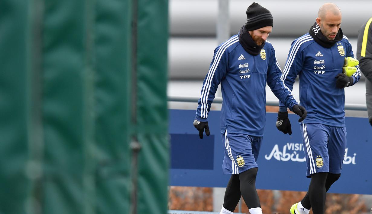 Javier Mascherano (kanan) dan Lionel Messi memasuki lapangan saat sesi latihan di City Football Academy, Manchester, (20/3/2018). Argentina akan melawan Italia pada laga persahabatan di Etihad Stadiu. (AFP/Anthony Devlin)