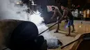 Para pekerja menyebarkan biji kopi robusta setelah disangrai secara tradisional di sebuah pabrik biji kopi kecil di Banda Aceh (14/11/2020). (AFP/Chaideer Mahyuddin)