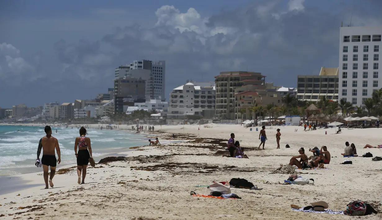 Wisatawan menikmati pantai sebelum kedatangan Badai Grace, di Cancun, Meksiko, Rabu (18/8/2021). Badai tropis Grace yang menguat menjadi badai pada 18 Agustus 2021 meluncur ke arah pantai Karibia, Meksiko dan mengancam akan membawa hujan lebat, banjir bandang dan gelombang besar. (AP/Marco Ugarte)