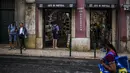 Turis berdiri di luar toko suvenir di pusat kota Lisbon, Portugal, Senin (13/9/2021). Portugal hari ini mengakhiri aturan wajib penggunaan masker di jalan-jalan. (PATRICIA DE MELO MOREIRA / AFP)