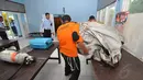 Beberapa petugas merapikan sejumlah barang temuan yang diduga berasal dari pesawat AirAsia QZ 8501 di salah satu ruangan di Lanud Iskandar, Pangkalan Bun, Kalimantan Tengah, Selasa (30/12/2014). (Liputan6.com/Miftahul Hayat)