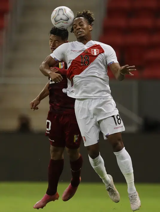 Gelandang timnas Peru, Andre Carrillo dan bek Venezuela Ronald Hernandez melakukan sundulan saat berebut bola pada laga terakhir penyisihan Grup B  Copa America 2021 di Estadio Nacional Mane Garrincha, Minggu (27/6/2021). Menghadapi Venezuela, Peru menang tipis dengan skor 1-0 (AP Photo/Bruna Prado)