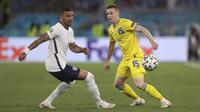 Gelandang timnas Ukraina, Viktor Tsyhankov berebut bola dengan bek Inggris, Kyle Walker pada perempat final Euro 2020 di Stadion Olimpiade, Roma, Italia, Minggu (4/7/2021) dini hari WIB. Inggris lolos ke semifinal usai menang telak atas Ukraina dengan skor 4-0. (Lars Baron/Pool Photo via AP)
